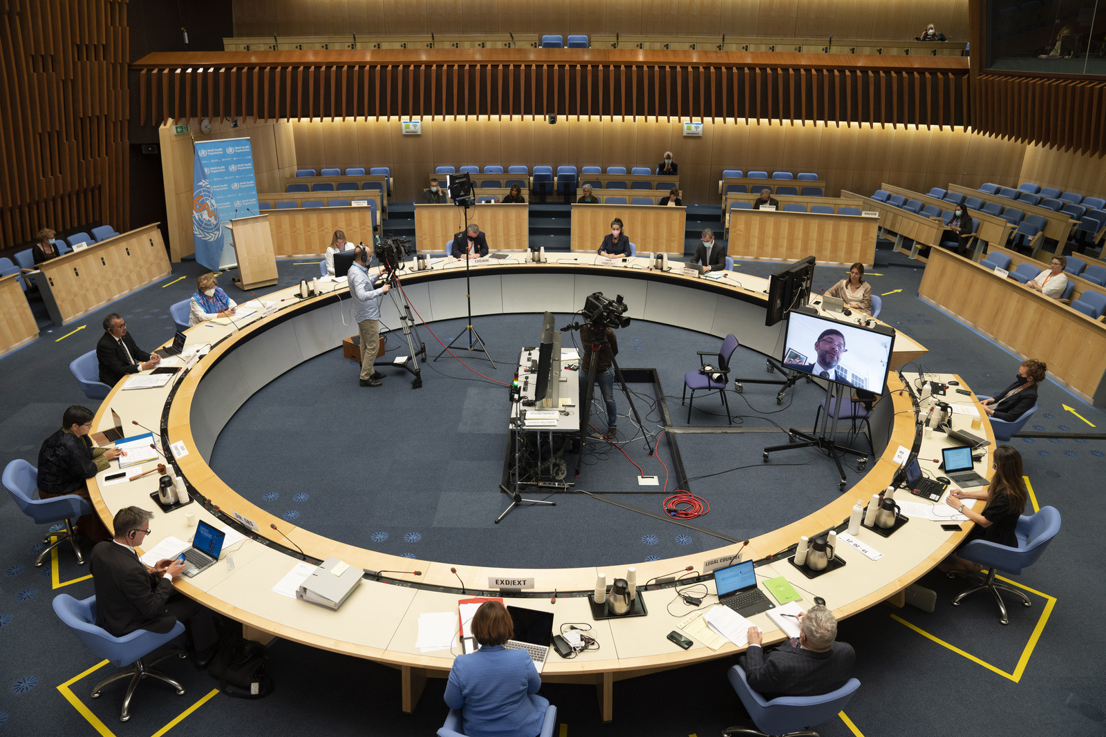A group of people sitting around a circular desk in a meeting room