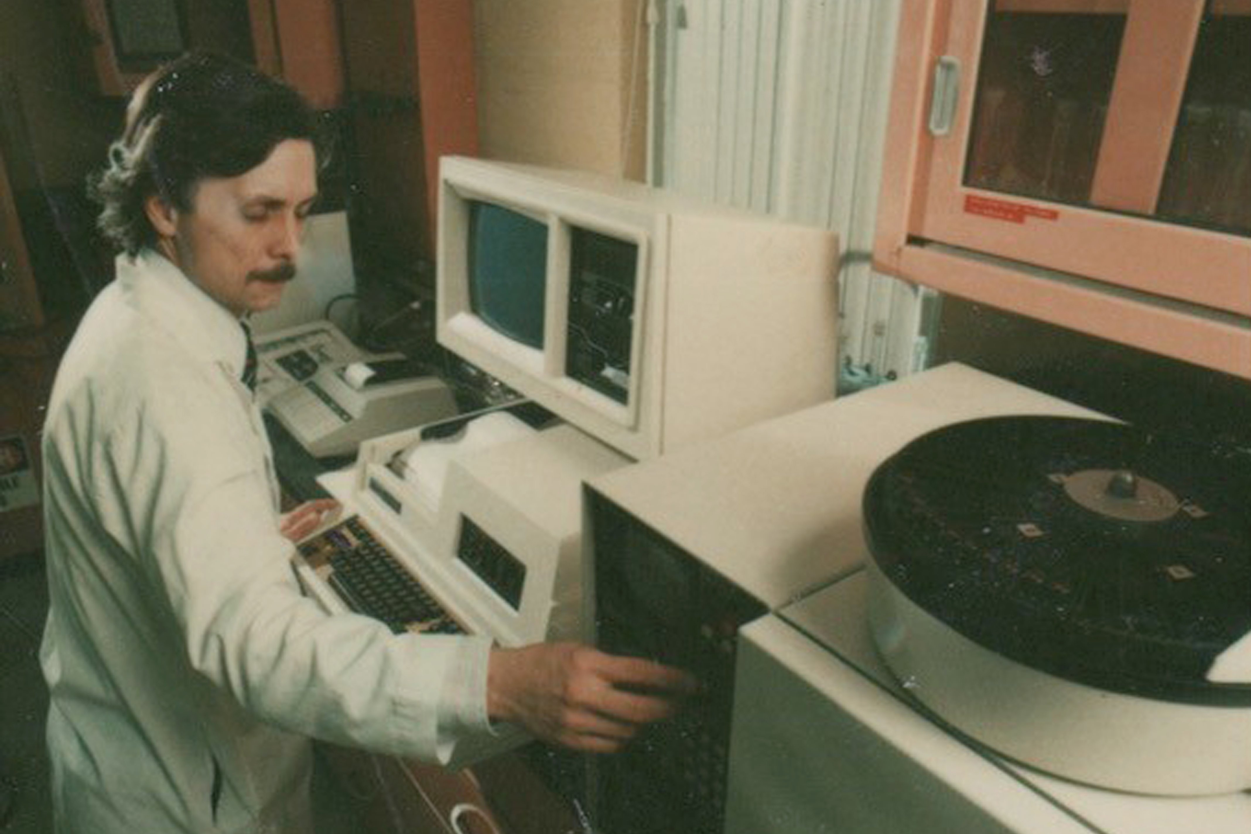 Bob Gyurik standing in front of an HPLC (high performance liquid chromatography). HPLC is now one of the most powerful tools in analytical chemistry, 1976.