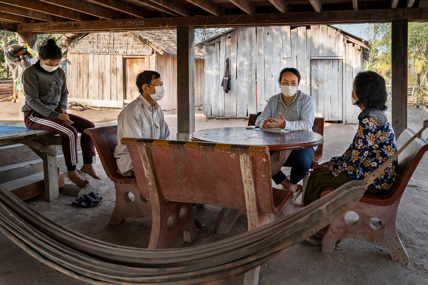 Woman visits the home of a recovered malaria patient in Cambodia