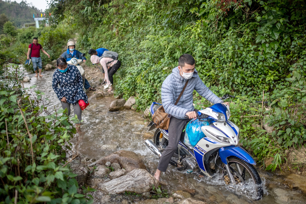 Malaria outreach teams on a difficult mountain path