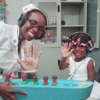 Nurse Precious Nyanga Nurse Precious Nyanga with three-year old child assessing hearing loss through play audiometry
