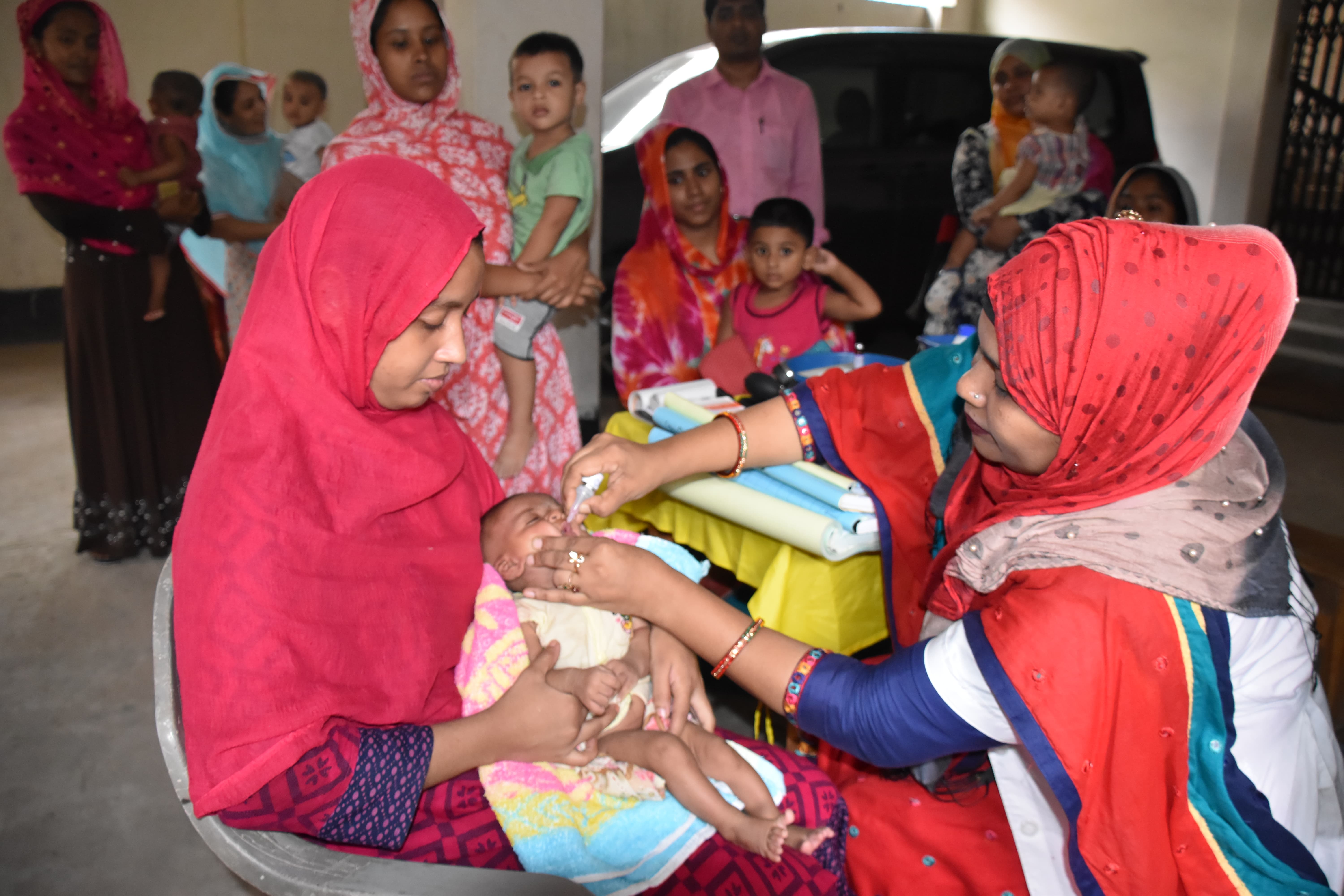 Joynab's daughter Nabila is being administered polio vaccine