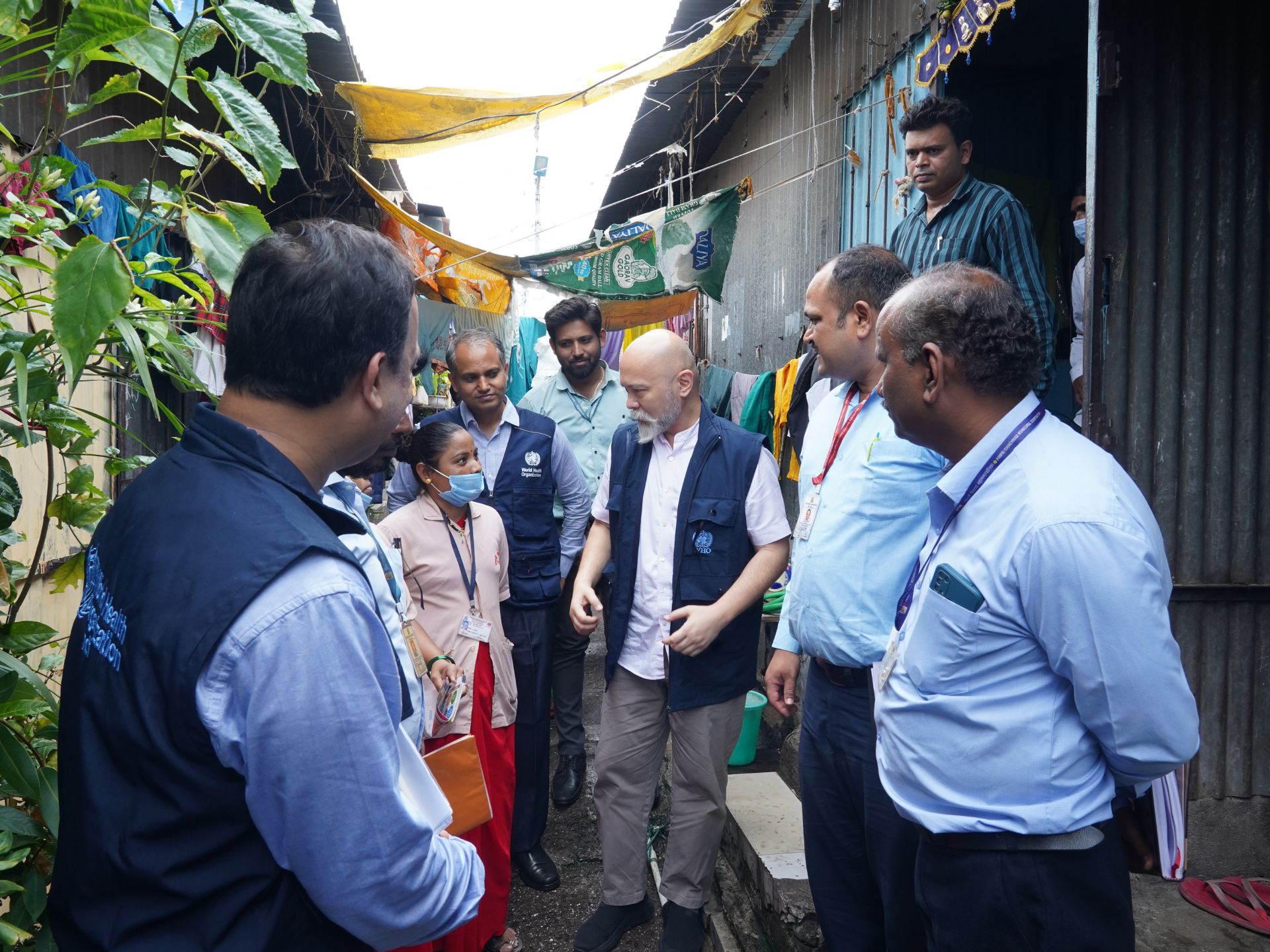 A group of health professionals standing in an outdoor alley, in Pune, India.