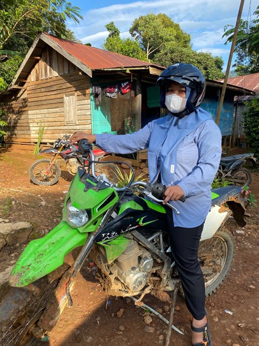 Eva, seorang bidan desa, bersama motor off-road miliknya.