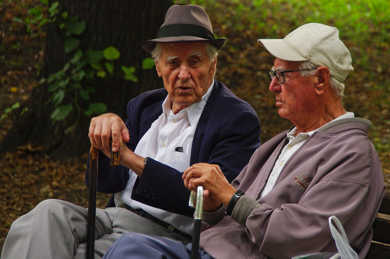 two elderly men sitting on a bench